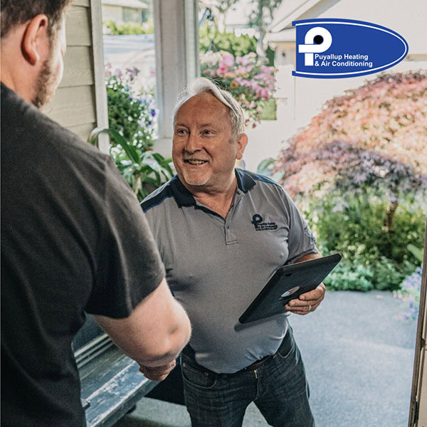 Puyallup technician shaking client's hand in doorway.