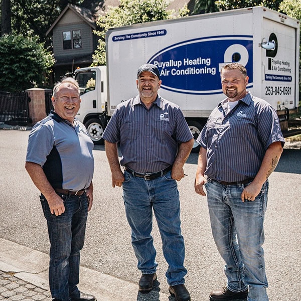 Puyallup HVAC team standing in front of branded company truck.