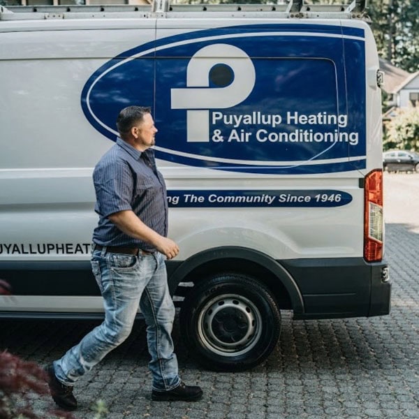 Puyallup technician walking alongside branded company truck.