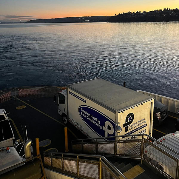 Puyallup HVAC branded truck in front of water and sunset.