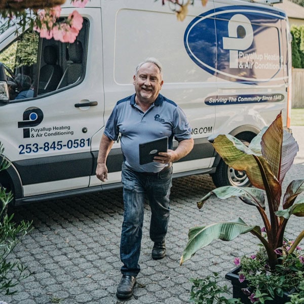 Puyallup HVAC technician leaving branded van outside at residential property.