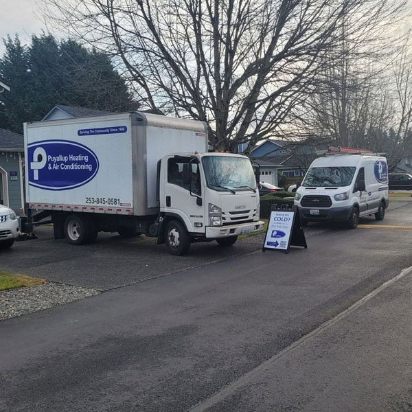 Puyallup HVAC branded truck and van outside of new construction site.