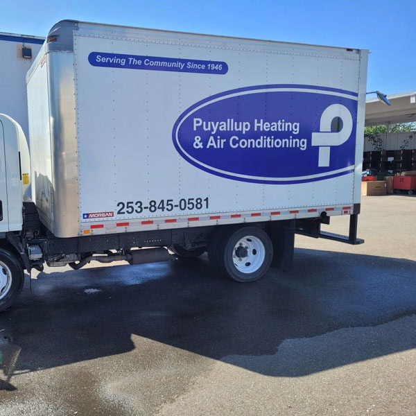 Puyallup HVAC branded truck in parking lot outside of warehouse.
