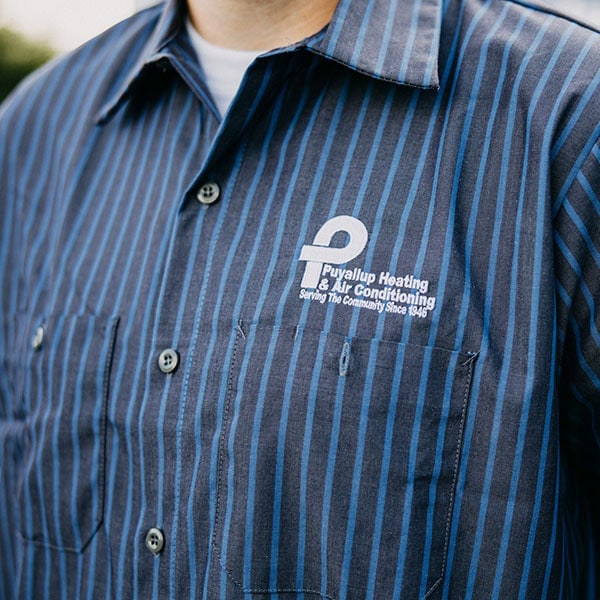 Puyallup HVAC technician's work shirt showcasing company logo.