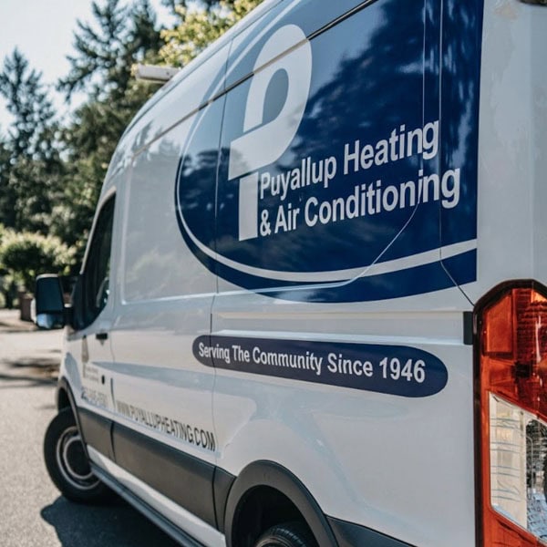 Heat Pump Repairs 2_600x600 Puyallup HVAC branded truck parked outside of residential job site.