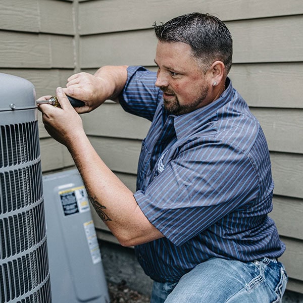 Puyallup HVAC technician working on outdoor cooling unit.