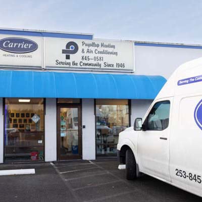 ev-charging-stations TOP Puyallup Heating & Air Conditioning branded work truck in parking lot.