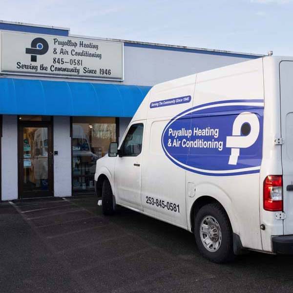 Puyallup Heating & Air Conditioning branded work truck in parking lot.