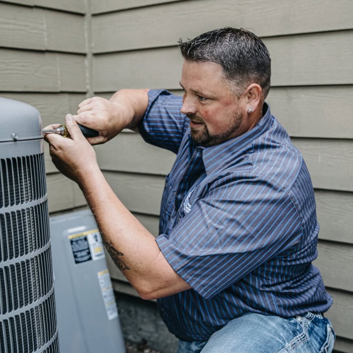 Puyallup HVAC technician working on outdoor air conditioning unit.