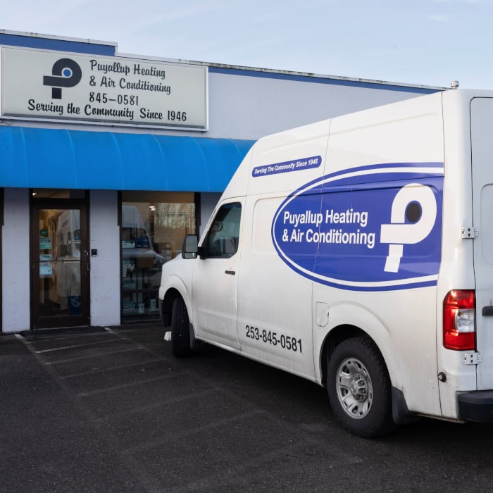 Puyallup HVAC branded work truck sitting in parking lot outside of storefront.
